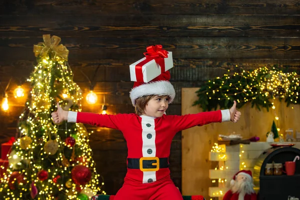 Barn med en julklapp på trä hus bakgrund. Gåva känslor. Hem Julstämning. — Stockfoto