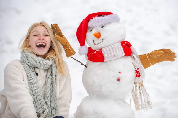 Vicces női modell pózol a téli időjárásban. Téli portré vicces lány a hóban Kert, hogy hóember. — Stock Fotó