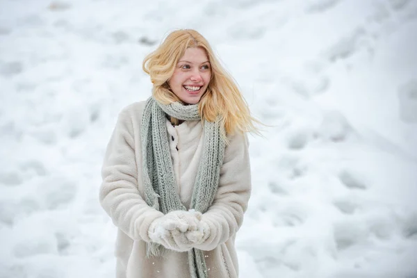 Κορίτσι που παίζει με το χιόνι ρίχνει μια μπάλα στις χειμερινές διακοπές. Ευτυχισμένη γυναίκα κρατά χιονόμπαλα στα χέρια. Πορτραίτο μιας ευτυχισμένης γυναίκας το χειμώνα. Χαρούμενο κορίτσι έξω.. — Φωτογραφία Αρχείου