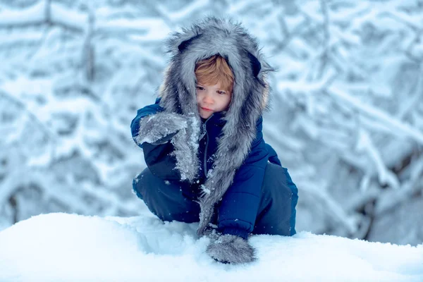 Retrato de invierno de un niño lindo en el jardín de nieve. Alegre niño divirtiéndose en Winter Park. Niños en el parque de invierno. Niños retrato de invierno . — Foto de Stock