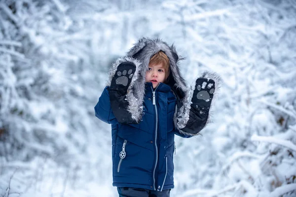 Lindo niño en árboles del parque de invierno cubiertos de nieve. Niños de invierno de ocio. Recuerdos de la infancia - hermoso invierno nevado sobre el prado. — Foto de Stock