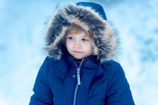 Niño de invierno posando y divirtiéndose. Retrato de invierno de un niño lindo en el jardín de nieve. Retrato al aire libre de lindo bebé en frío soleado invierno en el parque . —  Fotos de Stock