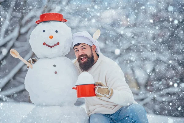 Chef de Noël. Homme dans la neige. Homme avec bonhomme de neige dans la cuisine d'hiver. Beau Père Noël cuisinier . — Photo