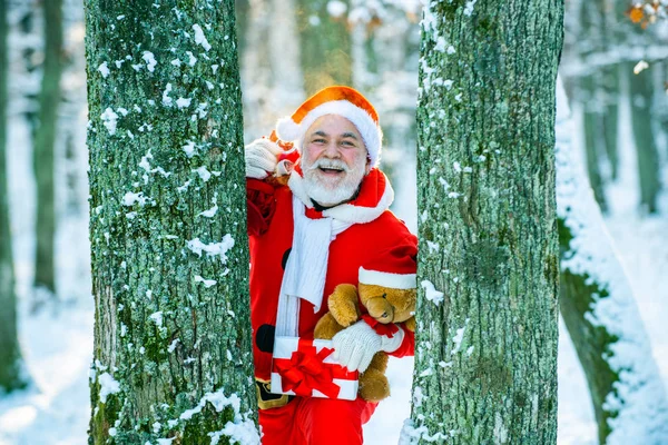 Joyeux Noël et bonne année concept. Père Noël est livré avec des cadeaux de l'extérieur. Santa en costume rouge marchant le long de la route de Noël . — Photo