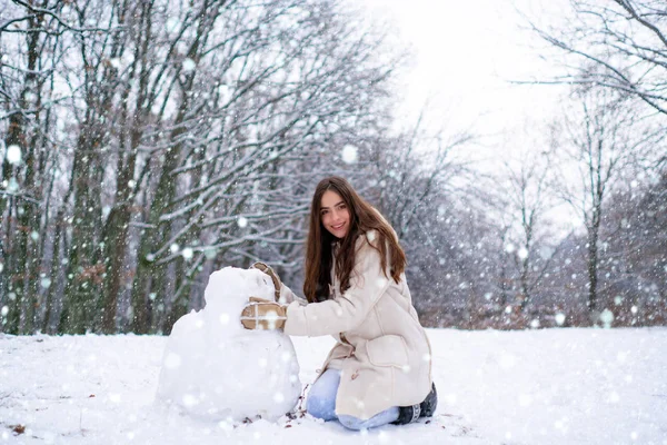 Κορίτσι στο χιόνι. Απολαμβάνοντας το χειμώνα της φύσης. Χειμερινή γυναίκα ευτυχισμένη. Όμορφη κοπέλα στο δάσος του χειμώνα σε λευκό κάτω σακάκι. — Φωτογραφία Αρχείου