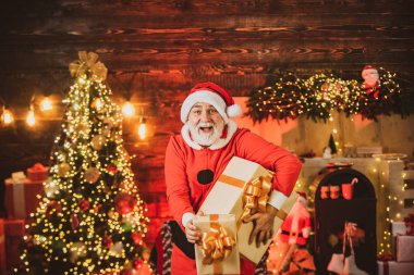 Kışın giyinmiş mutlu Noel Baba Noel ağacının yakınındaki Noel 'i düşün. Olgun bir Noel Baba portresi. Yeni yıl konsepti. Ev Noel atmosferi.