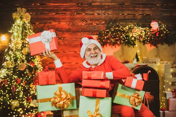 Lustige Weihnachtsmann halten Weihnachtsgeschenk. Weihnachtsmann wünscht frohe Weihnachten. — Stockfoto