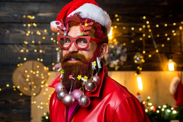 Santa vader met een witte baard poserend op de kersthouten achtergrond. Baard man heeft plezier in de buurt van de kerstboom binnen. Nieuwjaar Kerstconcept. — Stockfoto