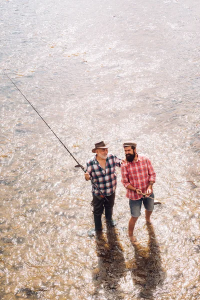 Uomini pesca rilassante mentre godendo hobby. Ottima presa. Divertimento e relax. Uomo maturo con amico pesca. Bella giornata per la pesca. E 'cosi' grande. Sono l'uomo più felice . — Foto Stock