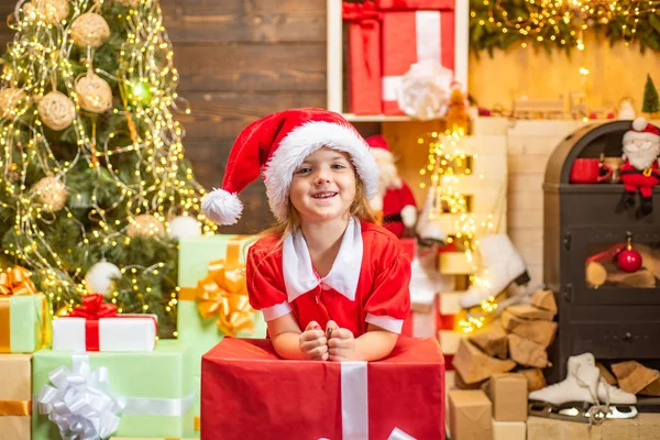 Miúdos giros a celebrar o Natal. Férias de Natal. Criança bonito feliz em chapéu de Papai Noel com presente ter um Natal. pequeno Papai Noel presente presente . — Fotografia de Stock