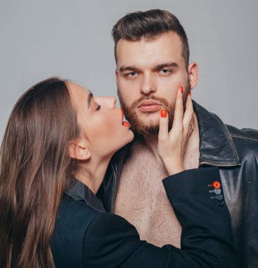 Touch his bristle. Girlfriend passionate red lips and man leather jacket. She adores male beard. Passionate hug. Passionate couple in love. Man brutal well groomed macho and attractive girl cuddling clipart