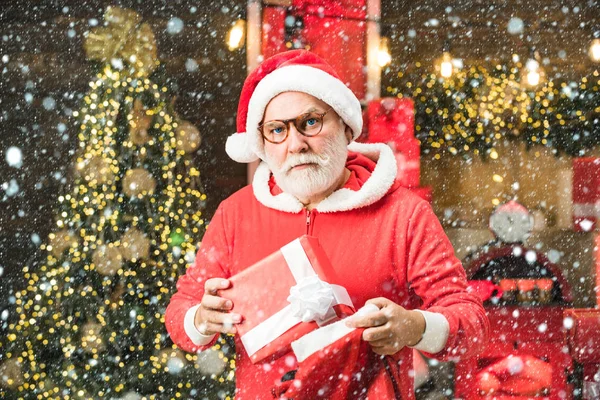 Santa farfar med vitt skägg poserar på julen trä bakgrund. Vinterkänslor. Snygg man klädd i julklänning. — Stockfoto
