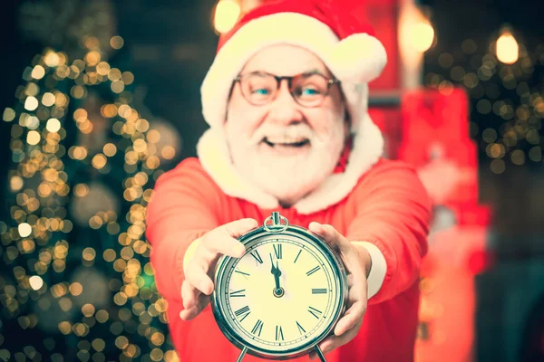 Weihnachtsmann - bärtiger, lustiger Senior. frohe Weihnachten. Weihnachtsmann zeigt auf der Uhr. — Stockfoto