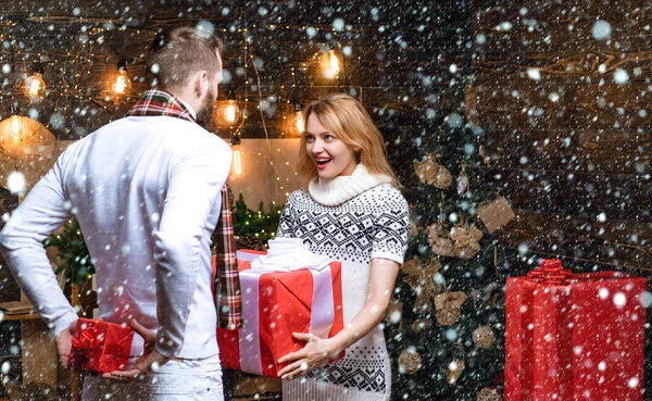 El interior brillante de Año Nuevo. Interior de Navidad. Positivo encantado pareja amorosa dándose regalos de Navidad. Feliz Año Nuevo. Regalos de Navidad. Celebrando Año Nuevo juntos. —  Fotos de Stock