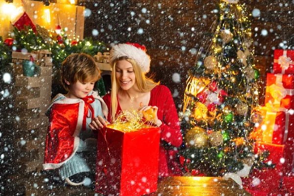 Family holiday. Cozy evening at home. Mom and kid play together christmas eve. Happy family. Mother and little child boy son friendly family having fun. Family having fun at home christmas tree