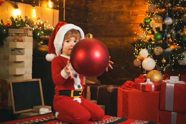 Feliz y brillante navidad. Precioso bebé disfrutar de la Navidad. Recuerdos de la infancia. Niño de Santa celebrar la Navidad en casa. Vacaciones familiares. Niño jugar cerca del árbol de Navidad. Cuenta atrás de año nuevo — Foto de Stock