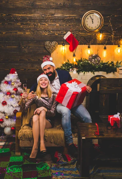 Nytt år familj med nuvarande julklapp framför julgranen. Stilig skäggiga hipster Santa med leende positiva unga kvinna. Uttryck och människor-konceptet. — Stockfoto
