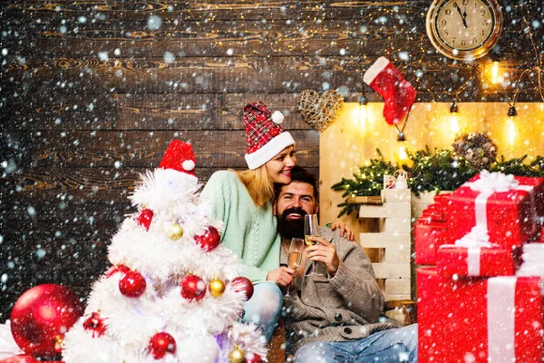 Par firande nyår. Vinter människor bär röd jultomten hatt. Julgran dekorera hemma. Gott Nytt År. Happy Christmas par. — Stockfoto