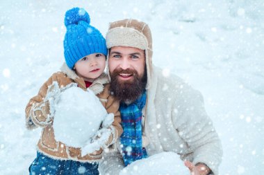 Noel Kutlaması tatili. Baba ve oğul kışlık kıyafetlerle oynarlar. Mutlu baba ve oğul kış Noel zamanı oynarlar. Baba ve oğlu kış beyaz arka plan üzerinde kartopu yapma.