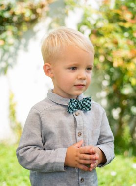 Doğadaki küçük şirin çocuk için güzel eğlenceli bir gün. Takım elbiseli ve papyonlu. Mutlu bir çocukluk. Küçük çocuk iyi yürüyüşler..