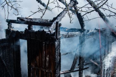 Yangın felaketinden sonra. Büyük yangından sonra duman. Yanıp kül olmuş ahşap ev.