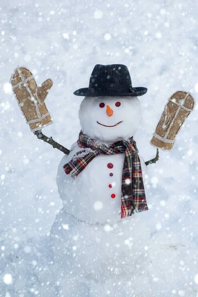 Feliz homem de neve sorridente no dia ensolarado de inverno. Bonecos de neve. Feliz inverno. Dia de boneco de neve e neve. Cavalheiro de neve de chapéu de inverno. Bonitos bonecos de neve de pé no inverno paisagem de Natal . — Fotografia de Stock