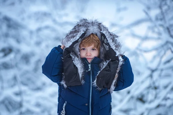 Un bambino carino che si diverte nel parco invernale sulla neve. Il concetto di bambino invernale gentilezza e infanzia . — Foto Stock