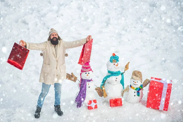 Noël hiver gens portrait. Préparation de Noël - drôle homme barbu avec boîte cadeau rouge faire bonhomme de neige. Bonne période hivernale. — Photo