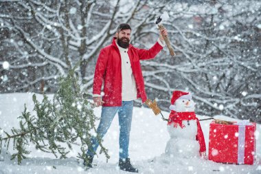 Mutlu oduncu ormandaki Noel ağacını kesiyor. Mutlu Noeller ve mutlu tatiller. Kış parkında Noel ağacı olan bir keresteci. Kış hissi.