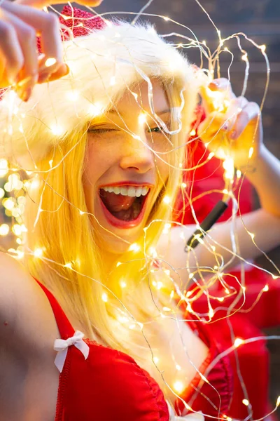 Göz kırpan kadın Noel Baba şapkası takıyor. Noel havai fişeği süsleme elementi. Kış tatili Seksi Noel kadın modeli. — Stok fotoğraf