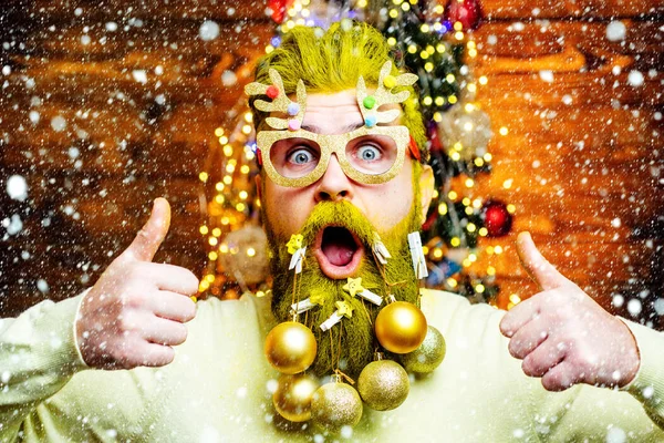 Retrato de moda de hombre guapo en el interior con árbol de Navidad. Concepto de año nuevo. Sexy hombre de Santa posando sobre fondo de madera vintage . — Foto de Stock