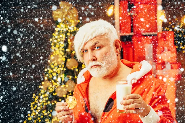 Weihnachten. Weihnachtsmann Claus genießt Plätzchen und Milch, die ihm an Heiligabend weggelassen werden. Weihnachtsmann isst an Heiligabend Plätzchen und trinkt Milch. — Stockfoto