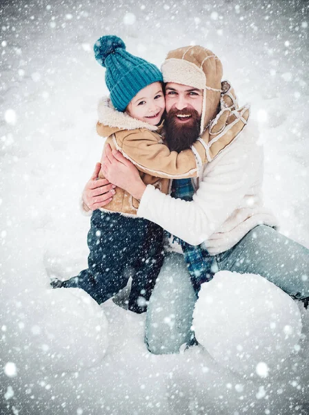 Батько і син Веселощі в Зимовому парку. Різдвяні свята. Сімейні свята і єдність. Татко і хлопчик посміхаються і обіймаються.. — стокове фото