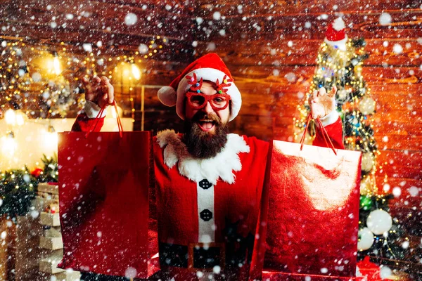 Preparazione di Natale - uomo che festeggia l'Anno nuovo. Styling Babbo Natale hipster con una lunga barba in posa sullo sfondo di legno di Natale. Pazzo, divertente Hipster Babbo Natale. — Foto Stock