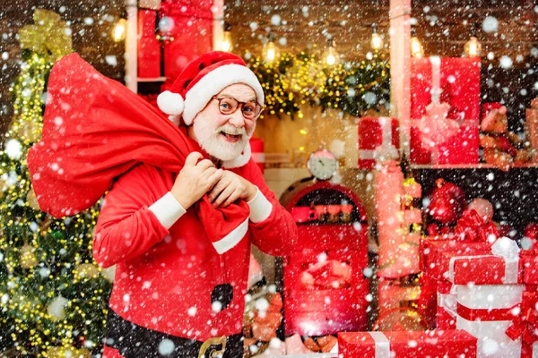 サンタはヴィンテージの木の背景にポーズ。サンタはメリークリスマスを願っています。ホリー・ジョリー・スワッグクリスマスとノエルサンタとクリスマスプレゼント. — ストック写真