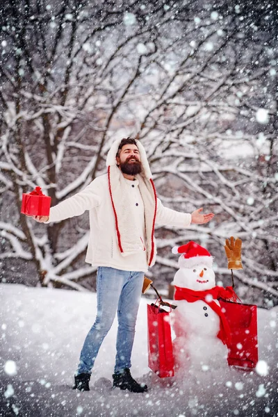 Концепція знижок та зимових продажів. Смішний сніговик з торговою сумкою - дисконтна та зимова концепція продажу. Щасливий усміхнений сніговик в сонячний зимовий день з щасливим батьком . — стокове фото