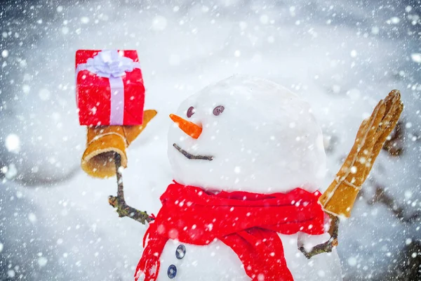 Snowman with shopping bag and gift on the white snow background. Greeting snowman. Merry Christmas and happy new year greeting card with copy-space. — Stock Photo, Image