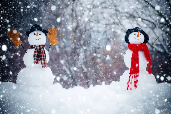 Saludo muñeco de nieve. Feliz hombre de nieve sonriente en el soleado día de invierno. Feliz Navidad y Feliz Año Nuevo. Dos muñeco de nieve sobre fondo de nieve . — Foto de Stock