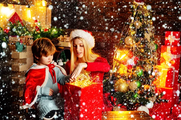 Family celebrate christmas. Mother with son and gift. Girl winter clothes santa claus hat celebrate christmas and happy new year. Christmas is coming.