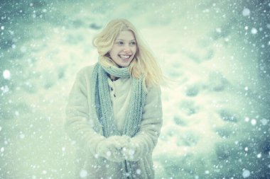 Kış tatilinde kar topu atan bir kız. Kışın mutlu bir kadının portresi. Dışarıdaki neşeli kız. Mavi tonlu.