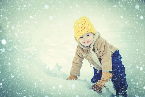 自然の中で冬の散歩で遊んで幸せな子供の男の子。雪と冬のフィールドで楽しい時間を過ごす幸せな子供。冬のクリスマスの感情. — ストック写真