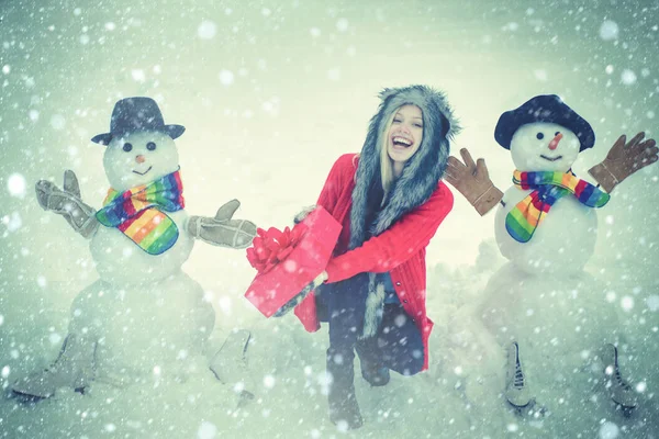 Winter portrait. Winter woman clothes. Making snowman and winter fun for people. Winter snow blue toned. — Stock Photo, Image