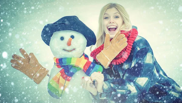 Winter snow blue toned. Funny Girl Love winter. Outdoor portrait of young pretty beautiful woman in cold sunny winter weather in park. Winter waman with Snowman on snow background. — Stock Photo, Image