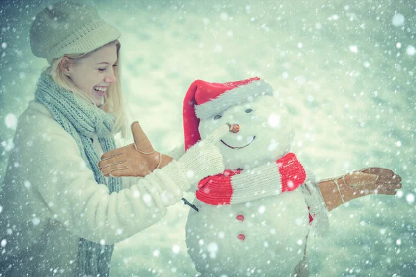 Funny winter girl playing with snow in park on white snow background. Snowing winter beauty fashion concept. Winter woman. — Stock Photo, Image