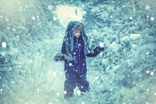 Παιδιά τρέχουν σε χιονισμένο χωράφι. Χαριτωμένο μικρό παιδί απολαμβάνει στο χειμερινό πάρκο στο χιόνι. Η έννοια της παιδικής καλοσύνης το χειμώνα και την παιδική ηλικία. — Φωτογραφία Αρχείου