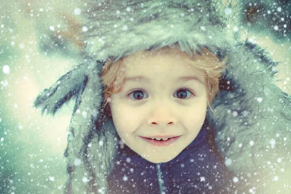 Ragazzo invernale faccia eccitata da vicino. Buon inverno. Bambino felice che gioca con la neve in una passeggiata invernale innevata. Inverno neve blu tonica . — Foto Stock