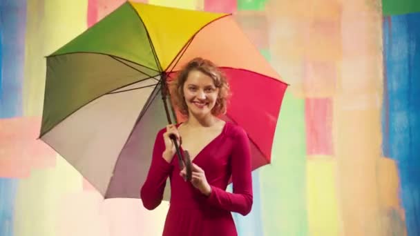 Female is holding the rainbow LGBT flag. Charming cheerful attractive nice cute girlfriend with umbrella. — Stock Video