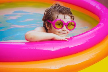 Yaz tatili ve tatil konsepti. Çocuklar yüzmeyi öğrenir. Yüzme havuzunun tadını çıkarıyorum. Çocuk havuzda yüzmekten mutlu. Yazın eğlenen bir çocuk. Yaz tatili.