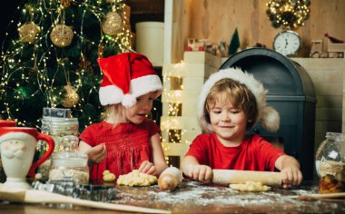 Eğlenceli tatil fırıncıları. Noel Baba şapkalı iki tatlı çocuk. Noel Baba için süt ve kurabiye. Noel arifesinde Noel Baba 'ya teşekkür etmek için kurabiye. Minnettar bir erkek ya da kıza hediye bıraktığı için..