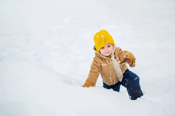 Glückliches Kind, das Spaß auf dem Winterfeld mit Schnee hat. Winterliche Weihnachtsstimmung. fröhlich lachender Kleinkind-Junge, der an Weihnachten im verschneiten Winterpark spielt — Stockfoto